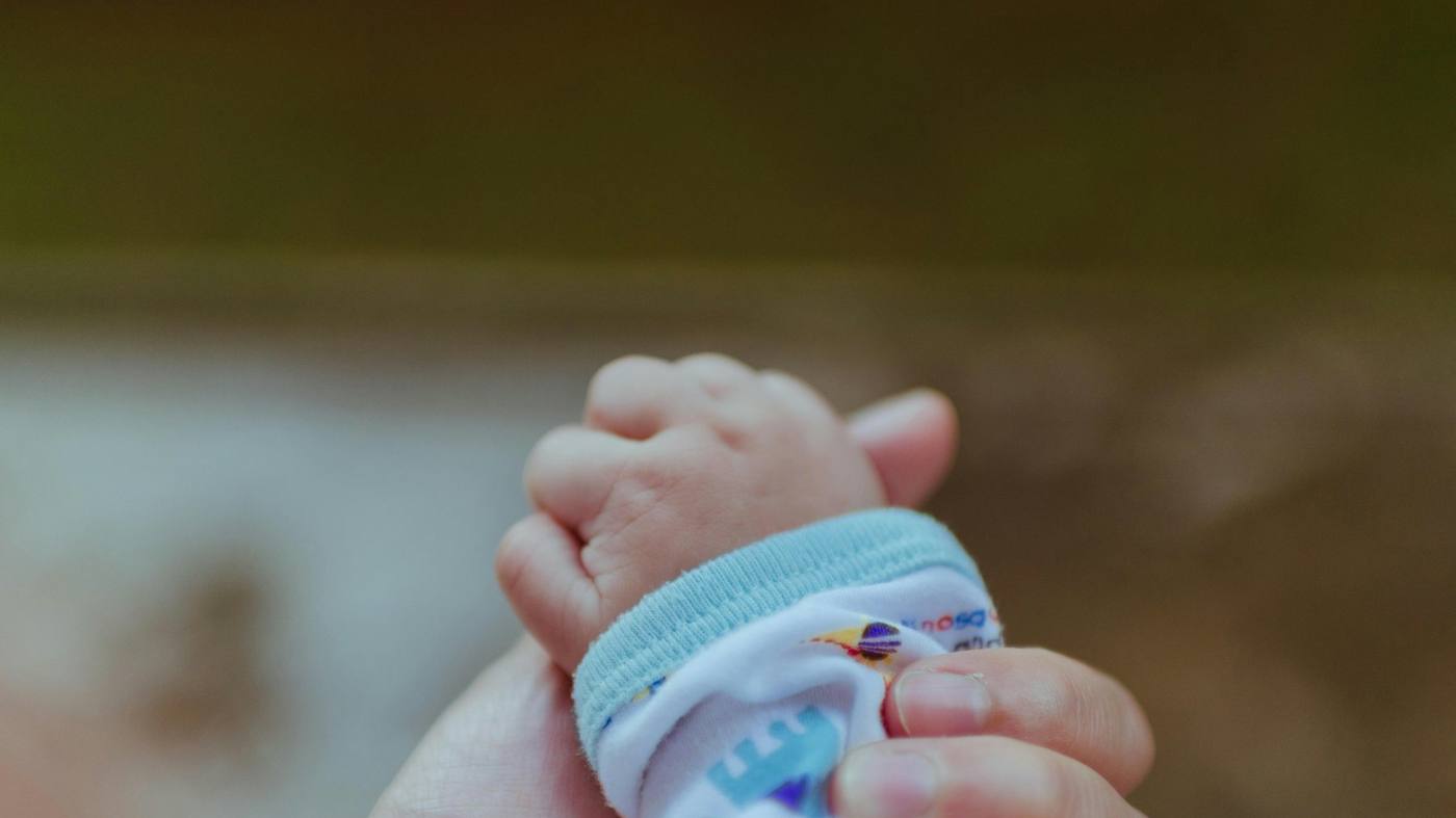 La main d'un bébé posée dans celle d'un adulte